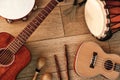 Ethnic musical instruments set: tambourine, wooden drum, brushes, wooden sticks, maracas and guitars laying on wooden Royalty Free Stock Photo