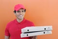 Ethnic pizza delivery guy in orange background Royalty Free Stock Photo