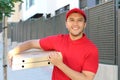 Ethnic pizza delivery worker in urban background