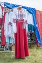 Ethnic souvenirs on the market counter. Traditional dresses and items of women`s clothing with hand-lined