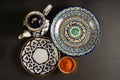 Ethnic Uzbek ceramics tableware on the black background.