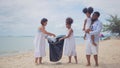 Ethnicity Happy asian and africans american Family picking up garbage activity on the beach Royalty Free Stock Photo