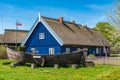 Beautiful old Lithuanian traditional wooden house with thatched roof and boat Royalty Free Stock Photo