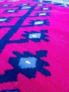 Etno oriental style of rug carpet made of wool with geometric shapes on red background for traditional house flooring design Royalty Free Stock Photo