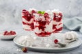 Eton mess, traditional english dessert, meringues, whipped cream, berry sauce and fresh raspberry in glass