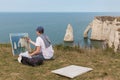 Artist painting famous Elephant cliffs near Etretat in Normandy, France