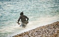 Etretat, France - June 29, 2012. Free diver with harpoon on coastline of English Channel in Normandy with nature arches