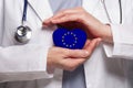 EU doctor holding heart with flag of European Union background. Healthcare, charity, insurance and medicine concept Royalty Free Stock Photo