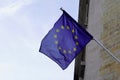 Eu Flag of European Union waving in wind on flagpole building against sky with clouds on sunny day Royalty Free Stock Photo