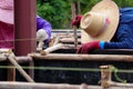 Eucalyptus wood used to support labours and blurred construction worker in the construction site.