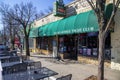 The Euclid Avenue Yacht Club with tables and chairs on the sidewalk and cars parked along the street with bare winter trees