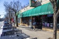 The Euclid Avenue Yacht Club with tables and chairs on the sidewalk and cars parked along the street with bare winter trees