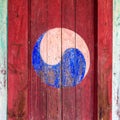 Eum and Yang Symbol, korean variant of Yin and Yang. Colorful retro painting with red background on a wooden door