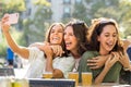 Euphoric girl friends taking selfie together on terrace. Royalty Free Stock Photo