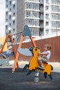 Euphoric little boy playing with a spring horse on a children playground