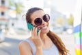 Euphoric woman talking to her smart phone in a bus station while is waiting Royalty Free Stock Photo