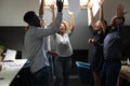 Euphoric young mixed race startup team throwing papers in air. Royalty Free Stock Photo