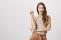 Eureka, I have great idea. Charming caucasian female in trendy outfit raising index finger and dropping jaw, remembering Royalty Free Stock Photo