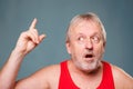 Eureka moment captured in studio! Senior man with finger up and open mouth, showing amazement