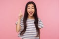 Eureka! Portrait of inspired girl with long hair in striped t-shirt pointing finger up with genius idea