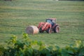 Eureka Spring, Arkansas, U.S - June 24, 2022 - A red tractor carrying hays on the field