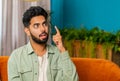 Thoughtful inspired Indian man make Eureka gesture raises finger came up with creative plan at home