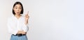 Eureka. Young smart asian girl has an idea, raising finger up, sharing her plan, pointing on top, standing over white Royalty Free Stock Photo