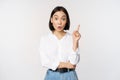 Eureka. Young smart asian girl has an idea, raising finger up, sharing her plan, pointing on top, standing over white Royalty Free Stock Photo