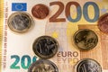 200 Euro banknote with coins on it, one cent to two Euro coins on yellow two hundred Euro bill Royalty Free Stock Photo