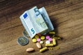 Euro banknote and coins with pills Royalty Free Stock Photo