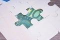 Euro banknote exposed from jigsaw puzzle on table
