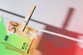 Euro banknote hung on a rope with clothespin and falling diagram chart Royalty Free Stock Photo