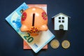 Toy House, piggy bank and euro on black background Royalty Free Stock Photo