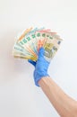 Euro banknotes in hand in surgical gloves.