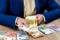 Euro banknotes in male hands and on table Royalty Free Stock Photo