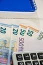 Euro banknotes, notepad and part of calculator on the table. Close-up. Royalty Free Stock Photo