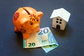 Toy House, piggy bank and euro on black background Royalty Free Stock Photo