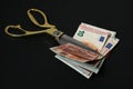 Euro banknotes and scissors on black background Royalty Free Stock Photo