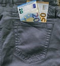 Euro banknotes sticking out of the back jeans pocket.