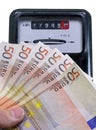 Euro banknotes to pay the electricity bill and the meter