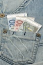 Euro banknotes and worn jeans