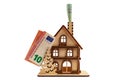 Euro bill in chimney and a wooden toy symbolic house on white isolated background. Heating concept Royalty Free Stock Photo