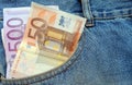 Euro bills in a blue jeans pocket