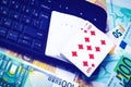 Euro bills, a deck of playing cards and a black keyboard. Concept of card games, casino or poker online. Royalty Free Stock Photo