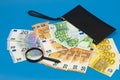 20 50 100 200 euro bills and magnifying glass with black wallet. Concept of counterfeit money. The concept of cash cash