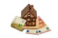 Euro bills and wooden toy symbolic house, white isolated background Royalty Free Stock Photo