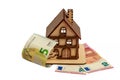 Euro bills and wooden toy symbolic house, white isolated background Royalty Free Stock Photo