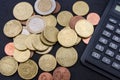 Euro cents coins and part of a black calculator on a black table. Close-up. Royalty Free Stock Photo