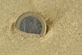 Euro coin covered by sand - Concept of finance and business Royalty Free Stock Photo