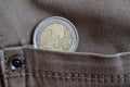 Euro coin with a denomination of 2 euro in the pocket of vintage gray denim jeans Royalty Free Stock Photo